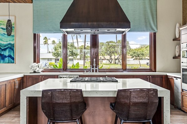 Clubhouse kitchen with modern appliances and island seating at Kapilina Beach Homes Apartments, offering a luxury experience in Ewa Beach