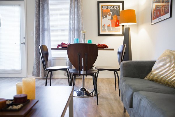 Elegant dining room with modern furniture at The U Apartments, featuring stylish decor and ample natural light