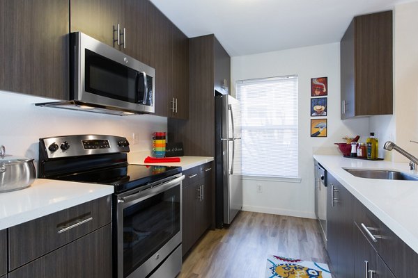 Modern kitchen with stainless steel appliances in The U Apartments
