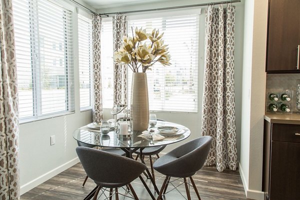 Dining room with modern furnishings and stylish lighting at Dylan Point Loma Apartments, a Greystar luxury property