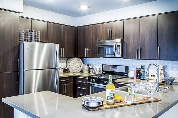 Modern kitchen with sleek countertops and stainless steel appliances at Dylan Point Loma Apartments