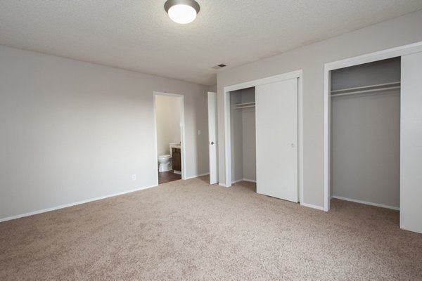 Cozy bedroom with modern decor and ample natural lighting at Woodside Park Apartments