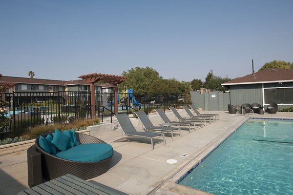 Woodside Park Apartments: Luxurious pool area with modern design and lounge chairs for relaxation