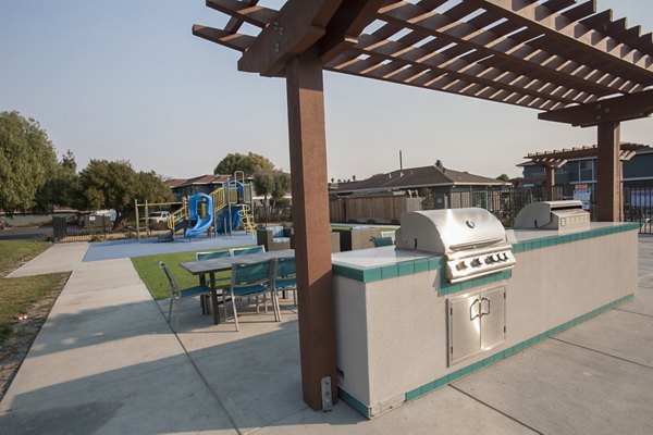 Outdoor grill area with modern seating at Woodside Park Apartments, perfect for social gatherings and summer barbecues