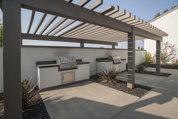 Outdoor grill area with modern seating at Sheridan Park Apartments, perfect for social gatherings and alfresco dining