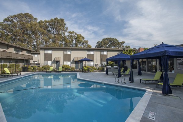 Outdoor pool with seating area at Monterey Townhouse, luxury apartments offering relaxation and leisure amenities