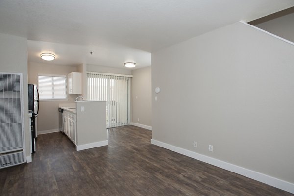Spacious living room featuring modern decor and large windows at Pacific Vista Apartments