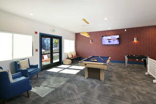 Game room with pool tables and arcade games at Waterscape Apartments