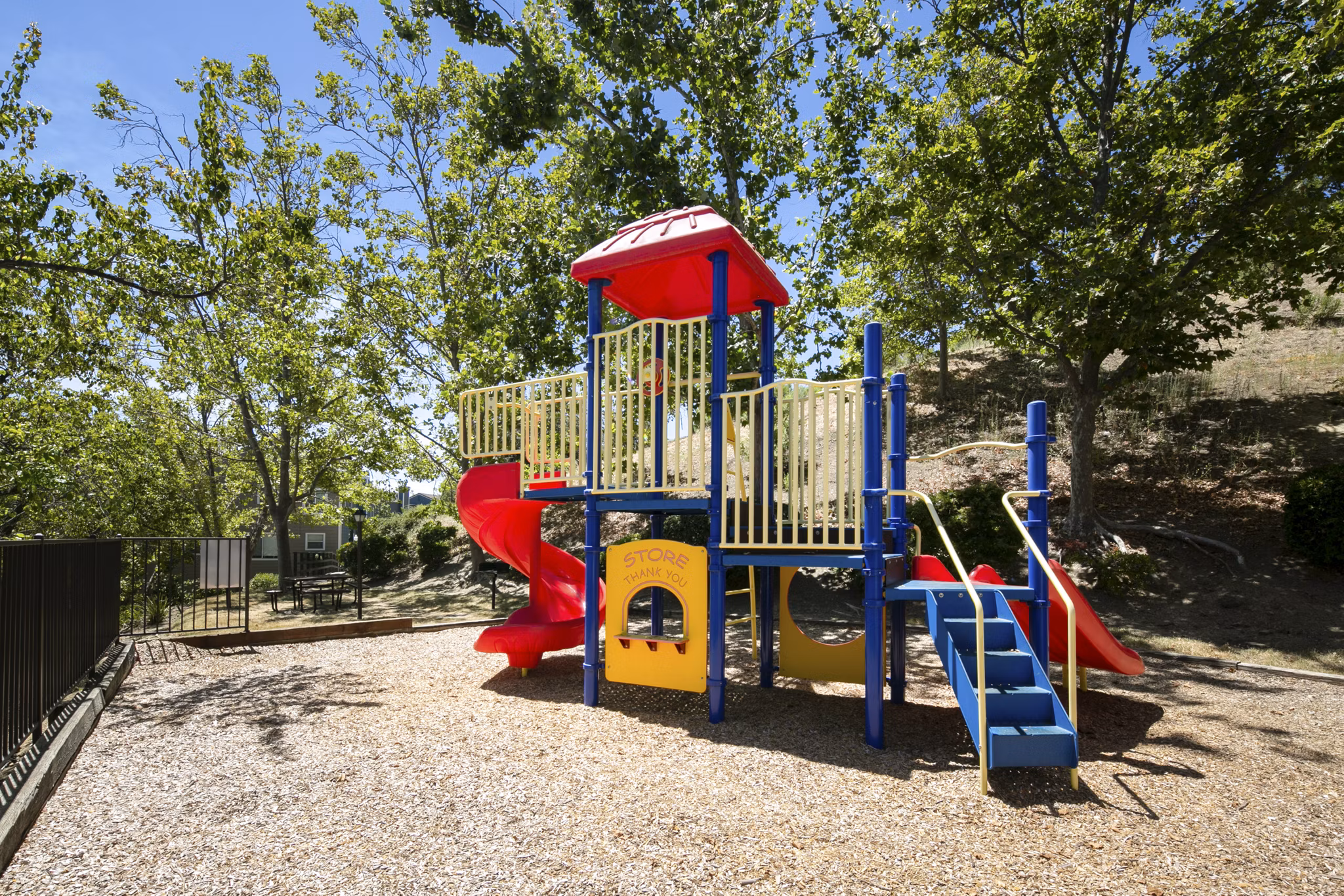 Colorful playground with slides and swings at Waterscape Apartments offering family-friendly amenities in a serene setting