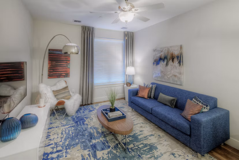 Modern living room with plush seating and large windows in Osprey Cove Apartments
