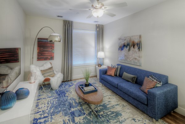 Modern living room with plush seating and large windows in Osprey Cove Apartments
