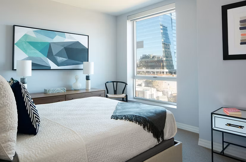 Bedroom featuring elegant decor and marina views at Watermark Seaport Apartments