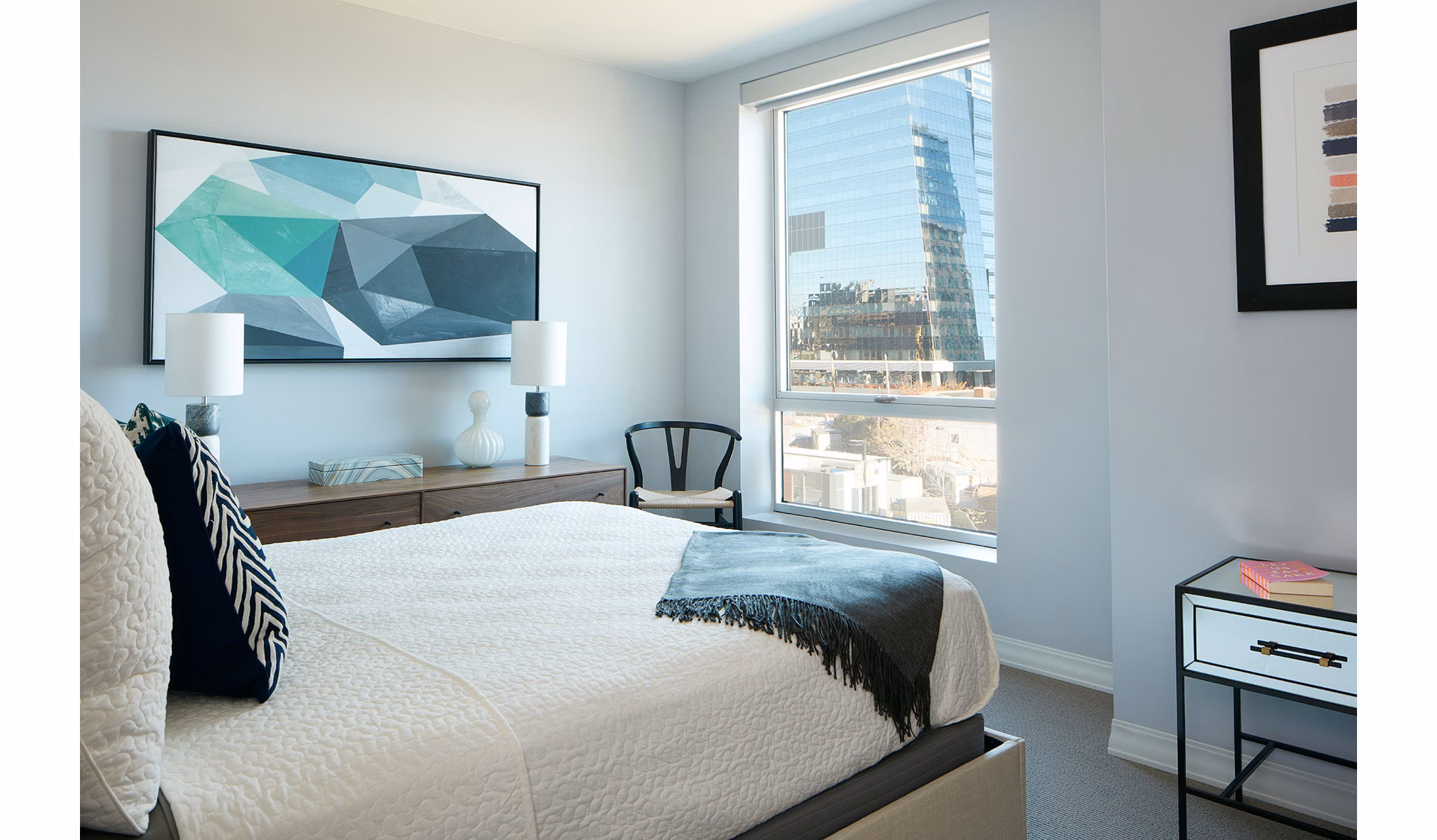 Bedroom featuring elegant decor and marina views at Watermark Seaport Apartments