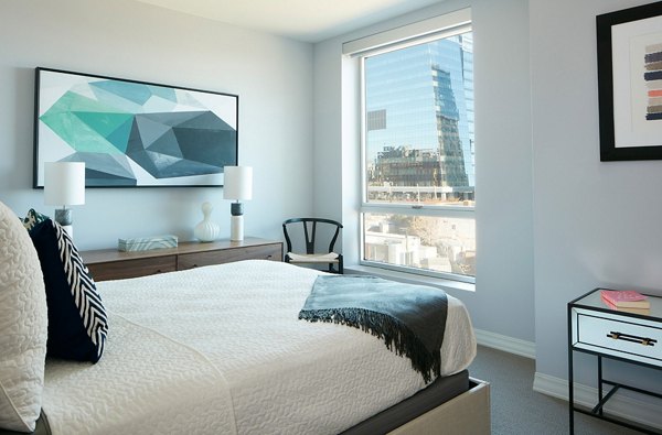 Bedroom featuring elegant decor and marina views at Watermark Seaport Apartments