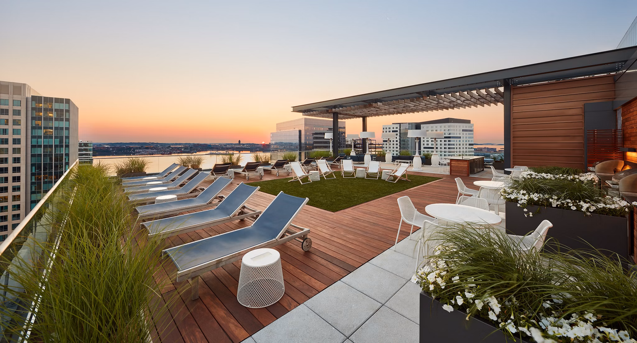 Scenic rooftop deck at Watermark Seaport Apartments overlooking city skyline, perfect for social gatherings and relaxation in luxury surroundings