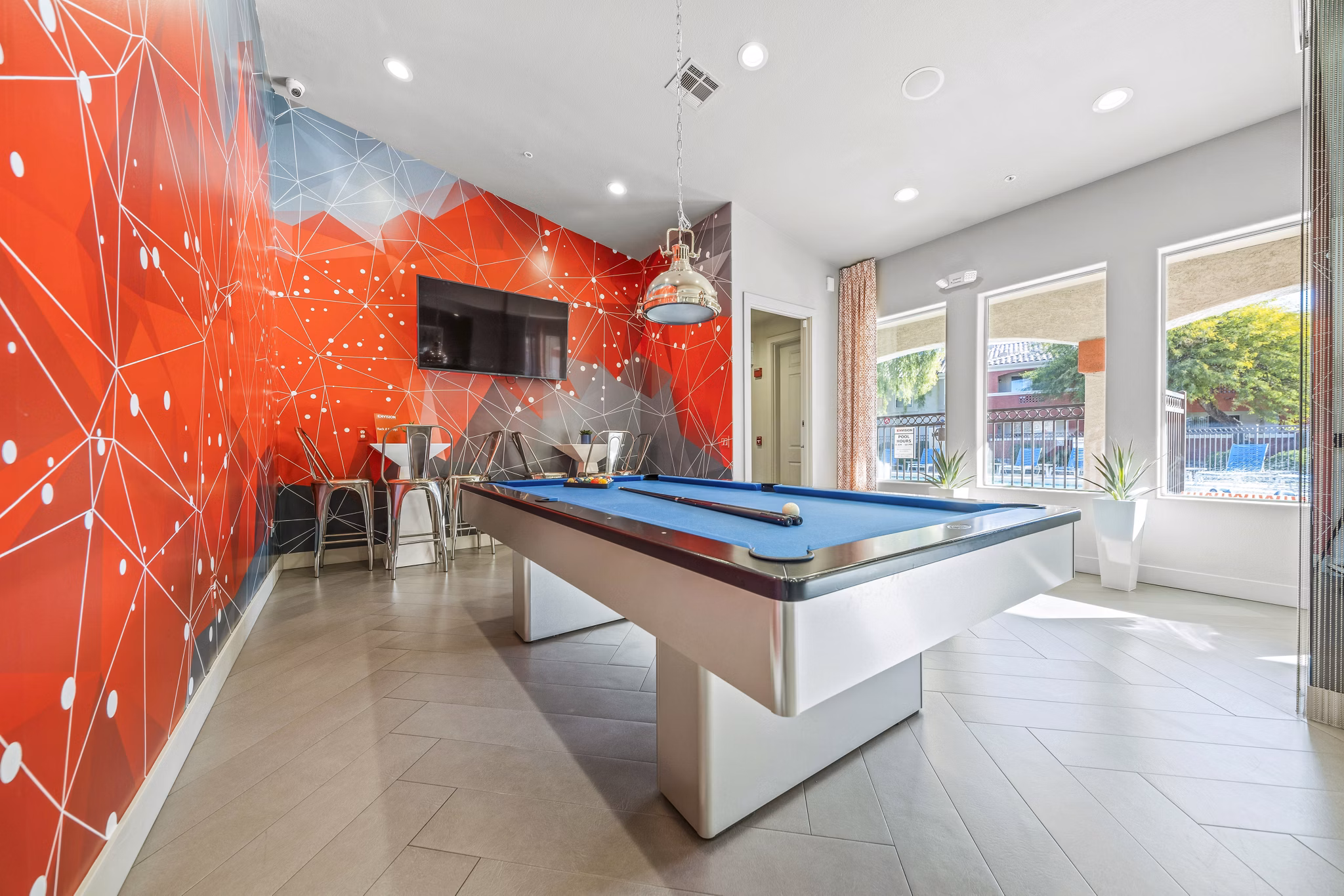 Clubhouse game room with billiards and lounge seating at Envision Apartments, luxury living by Greystar