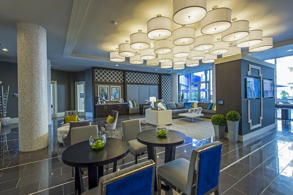 Spacious clubhouse lounge with contemporary decor at Elan Memorial Park Apartments, featuring ample seating and stylish lighting accents
