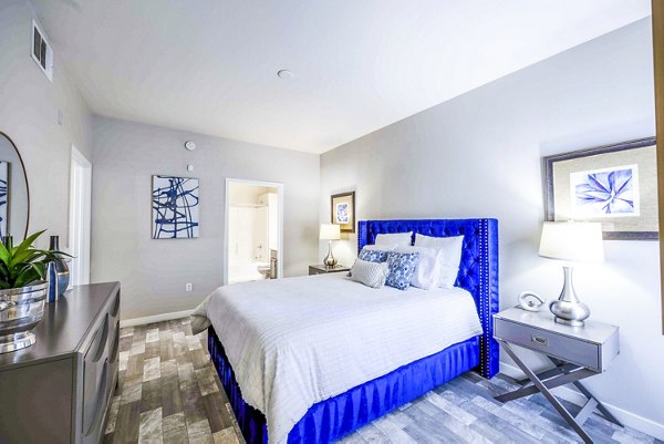 Cozy bedroom with stylish decor and large windows at Tesoro Ranch Apartments