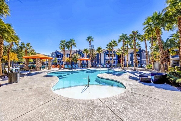 Resort-style pool with palm trees at Tesoro Ranch Apartments offering luxury living in a serene environment
