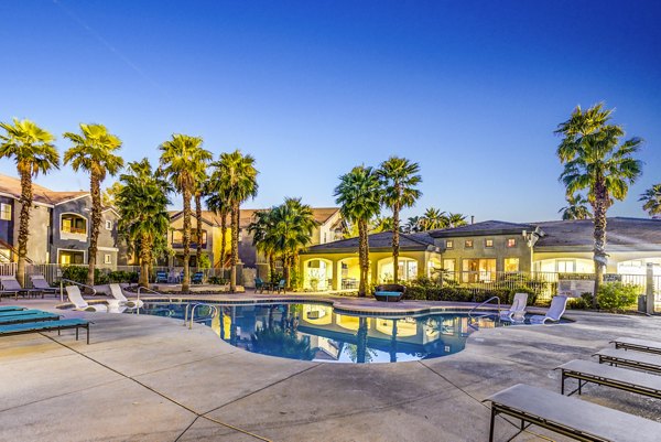 Resort-style pool with lounge chairs at Tesoro Ranch Apartments, offering luxury living amenities in a serene setting