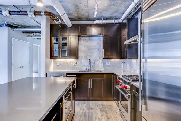 Contemporary kitchen with stainless steel appliances in Sequel Apartments, luxury living redefined