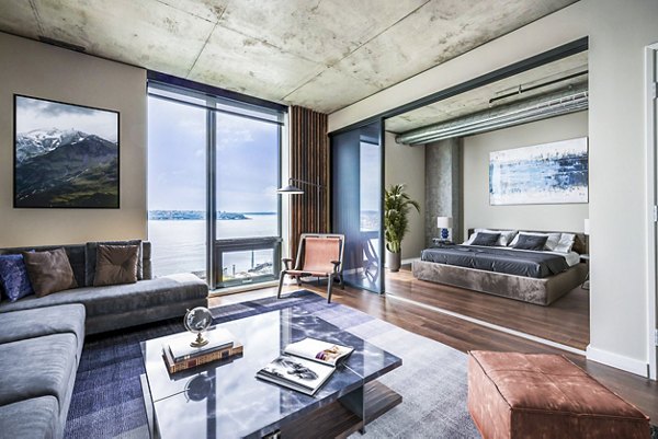 Cozy living room featuring modern decor and large windows at Sequel Apartments