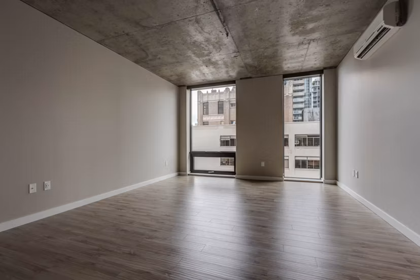 Open-concept living room with modern furnishings at Sequel Apartments, featuring sleek design and natural light