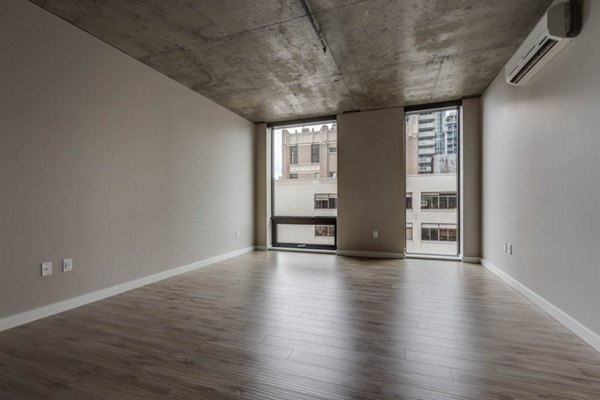 Open-concept living room with modern furnishings at Sequel Apartments, featuring sleek design and natural light