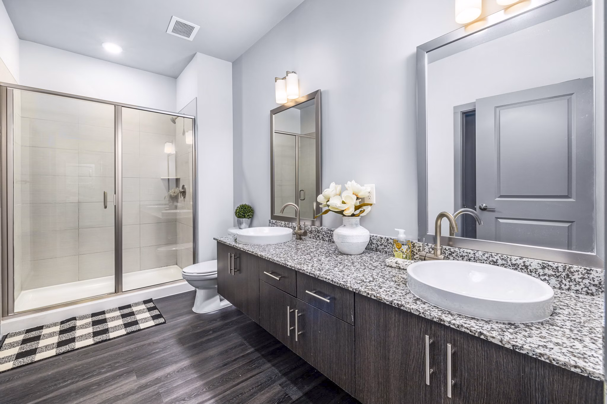 Luxury bathroom featuring sleek fixtures and large mirror at District Lofts Apartments