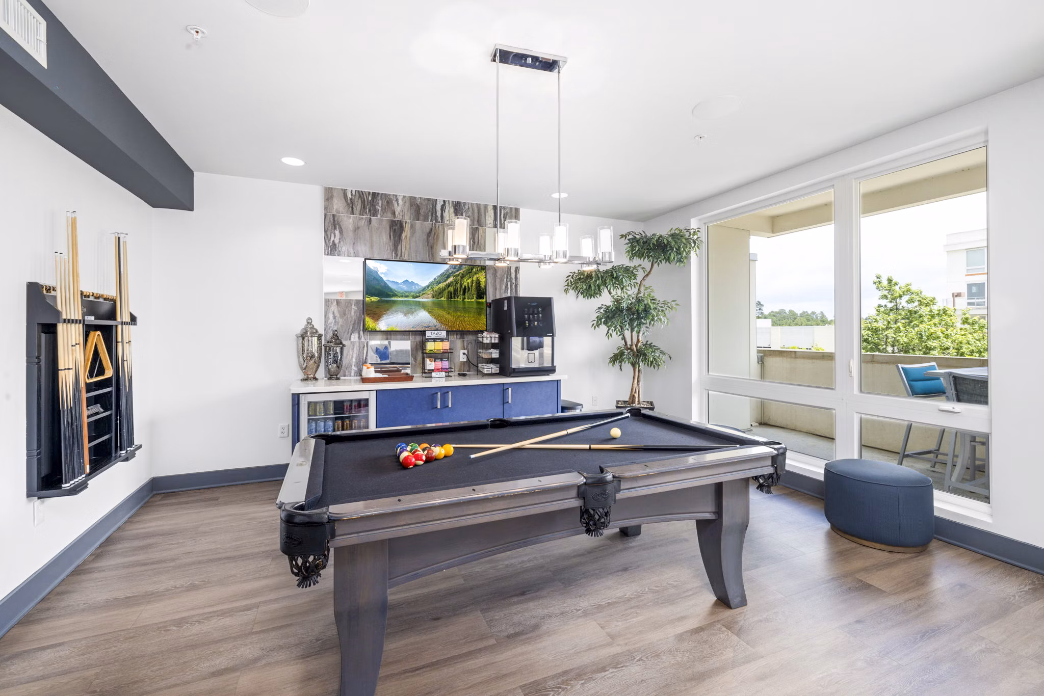Modern clubhouse game room with pool tables and seating at District Lofts Apartments
