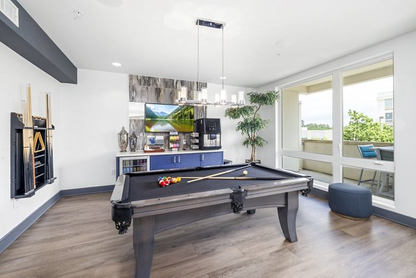 Modern clubhouse game room with pool tables and seating at District Lofts Apartments