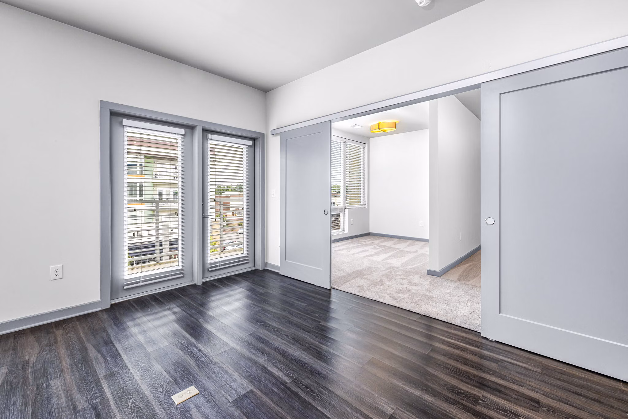 Spacious living room with modern decor and large windows at District Lofts Apartments, offering luxurious living in a vibrant community