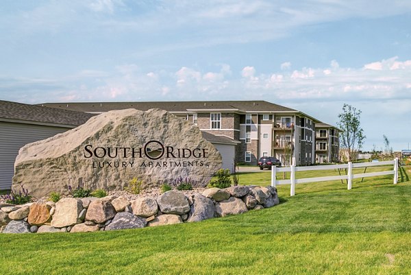 South Ridge Luxury Apartments sign on a large rock at the entrance of a modern apartment complex