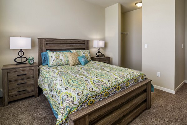 Elegant bedroom with large windows and contemporary furnishings in South Ridge Apartments
