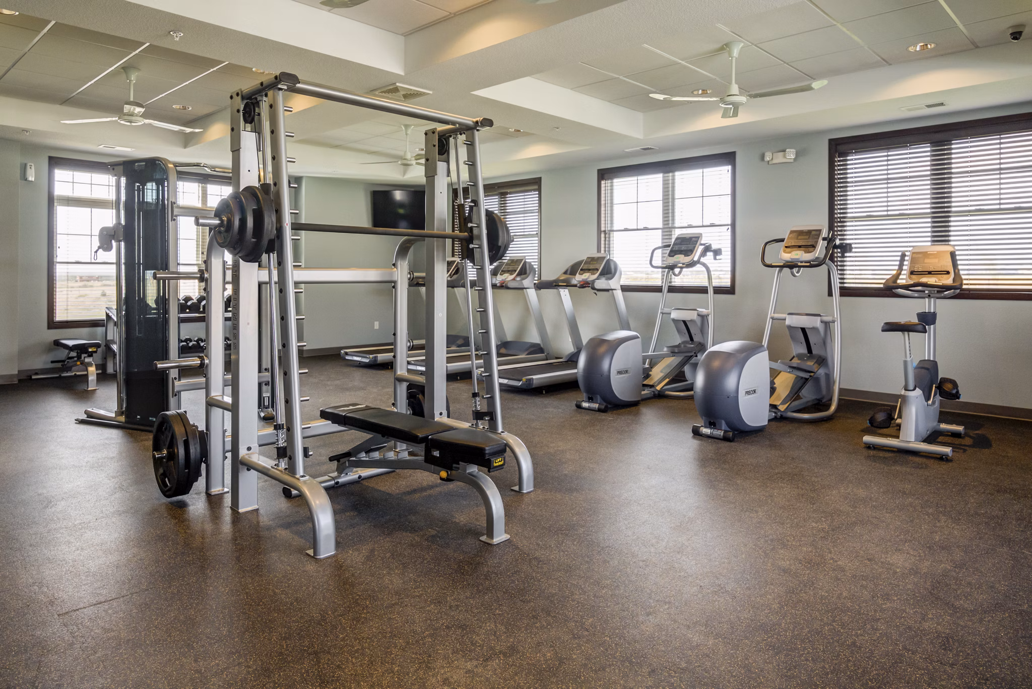 Fully-equipped fitness center at South Ridge Apartments with modern exercise machines and free weights