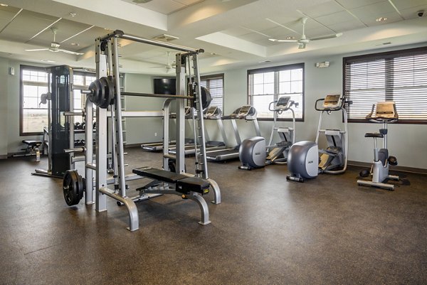 Fully-equipped fitness center at South Ridge Apartments with modern exercise machines and free weights