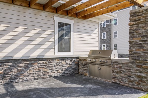 Outdoor grill area with modern seating at South Ridge Apartments, perfect for social gatherings and dining al fresco