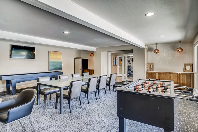 Clubhouse game room with billiards and seating area at Park 120 Apartments