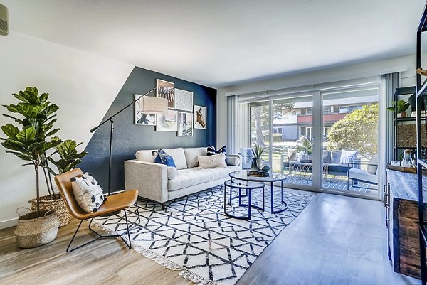 Spacious living room with modern decor and large windows in Park 120 Apartments