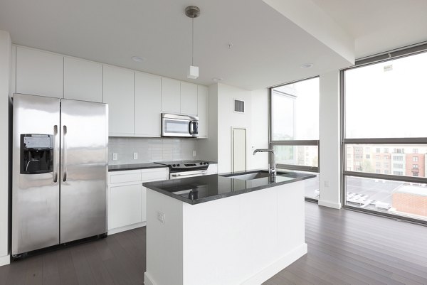 Modern kitchen with sleek countertops and stainless steel appliances in VINE Apartments