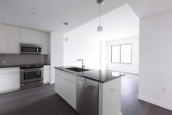 Modern kitchen with granite countertops and stainless steel appliances at VINE Apartments