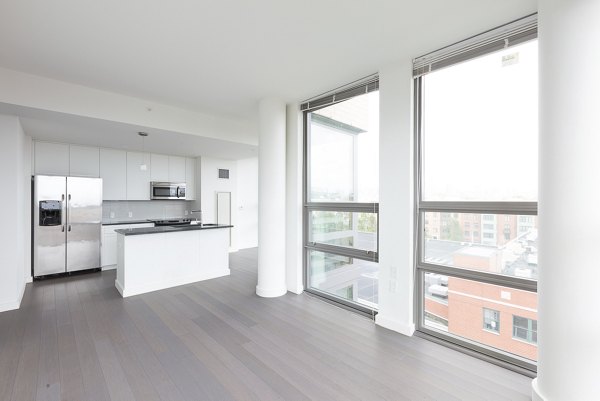 Spacious living room with modern decor and large windows at VINE Apartments