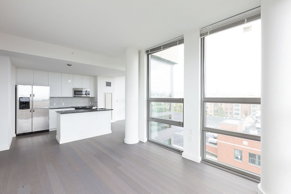 Spacious living room with modern decor and large windows at VINE Apartments