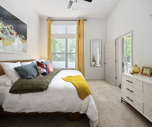 Cozy bedroom with designer furnishings at 1133 on the Square Apartments