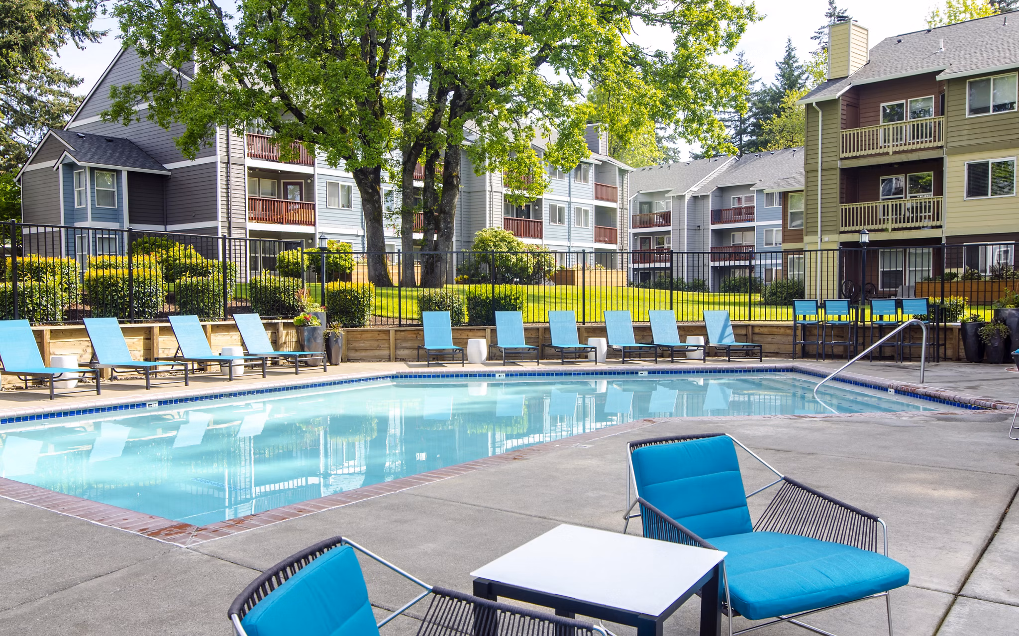Outdoor pool at Heatherbrae Commons Apartments with lounge seating and landscaped surroundings