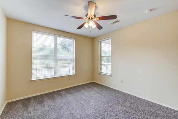 Master bedroom with elegant decor and large windows at Overture Ridgmar Apartments