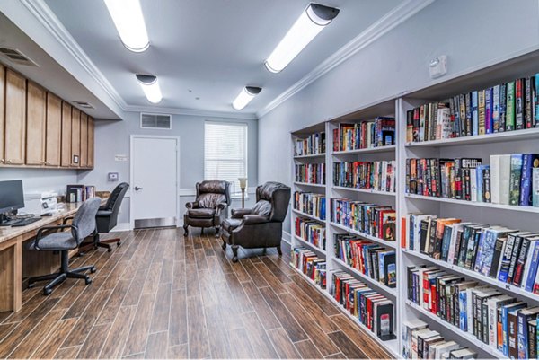 Clubhouse library with cozy seating and bookshelves at Overture Ridgmar Apartments in a modern luxury setting