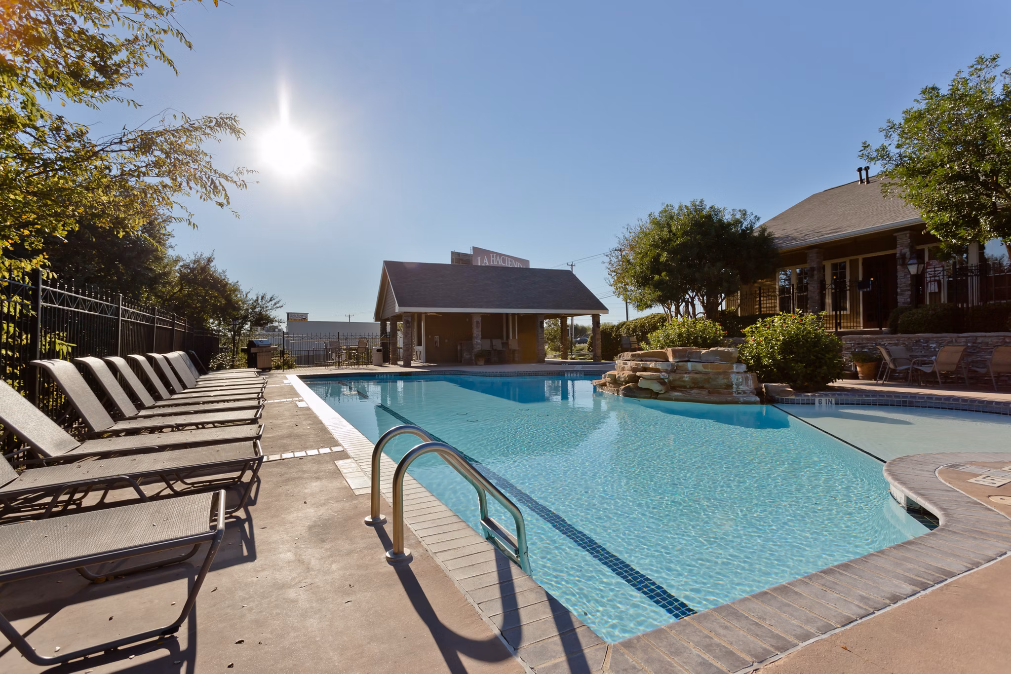 Modern pool with sun loungers at The Ravinia Apartments
