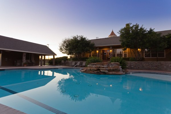 Outdoor pool with surrounding deck and lounge chairs at The Ravinia Apartments, a luxury property
