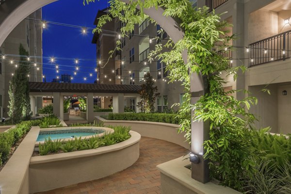 Tranquil courtyard at High Point Uptown Apartments featuring lush greenery and seating areas